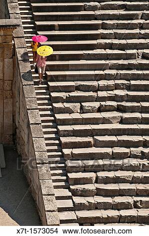 Two tourists descending the steps at the Classical Greek theatre at Ancient Epidaurus, Argolid, Peloponnese, Greece View Large Photo Image Picture - Two tourists descending the steps at the Classical Greek theatre at Ancient Epidaurus, Argolid, Peloponnese, Greece. Fotosearch
