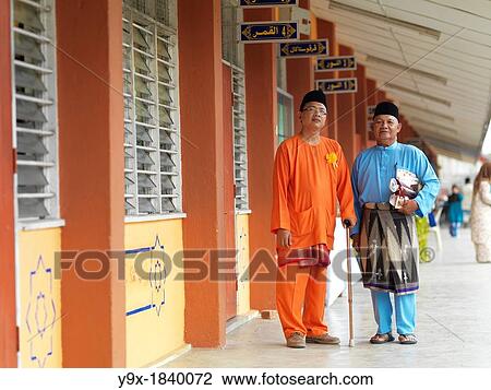 Two traditionally dressed men standing in front of a school View Large Photo Image Stock Image - Two traditionally dressed men standing in front of a school. Fotosearch