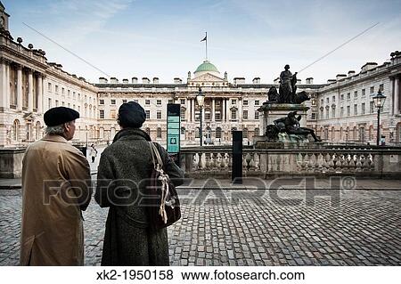 Stock Photo - Two travelers enjoying Somerset House court, London, UK. Fotosearch
