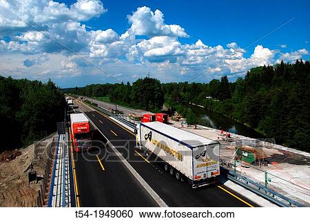 Two trucks meet on a highway construction site View Large Photo Image Stock Image - Two trucks meet on a highway construction site. Fotosearch