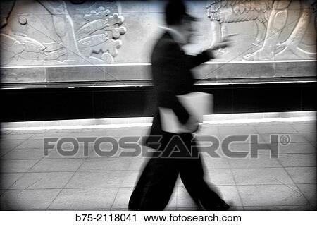 Two unrecognizable men with a folder under his arm, walking down the street. London, England, UK, Europe. View Large Photo Image Stock Image - Two unrecognizable men with a folder under his arm, walking down the street. London, England, UK, Europe.. Fotosearch