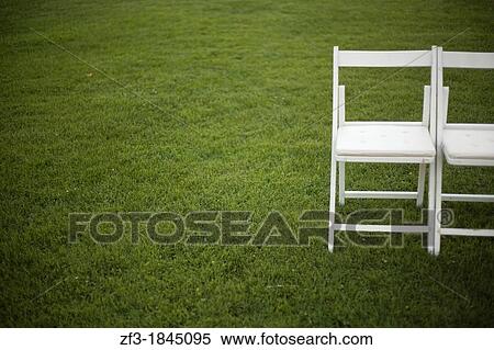 Two white chairs on the grass View Large Photo Image Stock Photography - Two white chairs on the grass. Fotosearch