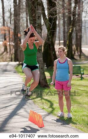 two women, both in late 20? s, doing exercises in outdoor setting View Large Photo Image Stock Photo - two women, both in late 20? s, doing exercises in outdoor setting. Fotosearch