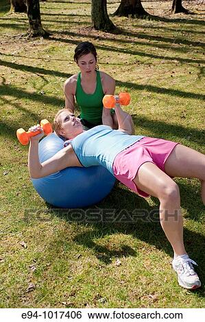 two women, both in late 20? s, doing exercises in outdoor setting View Large Photo Image Stock Photograph - two women, both in late 20? s, doing exercises in outdoor setting. Fotosearch