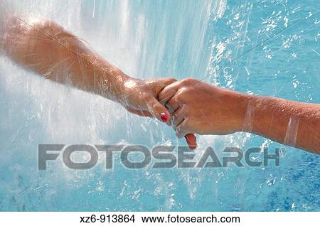 two women holding hands under running water from a spa View Large Photo Image Picture - two women holding hands under running water from a spa. Fotosearch