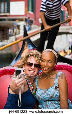 Two women in gondola taking a self portrait with digital camera, Venice, Italy View Large Photo Image Stock Image - Two women in gondola taking a self portrait with digital camera, Venice, Italy. Fotosearch