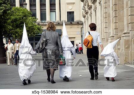 Two women leading young penitents to the church for a Holy Week procession on Palm Sunday, Seville, Spain View Large Photo Image Picture - Two women leading young penitents to the church for a Holy Week procession on Palm Sunday, Seville, Spain. Fotosearch