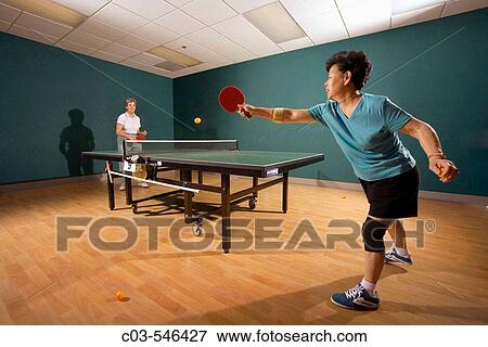 Stock Photo - Two women over age 70 play ping pong at a seniors? athletic facility in the retirement community of Laguna Woods, CA.. Fotosearch