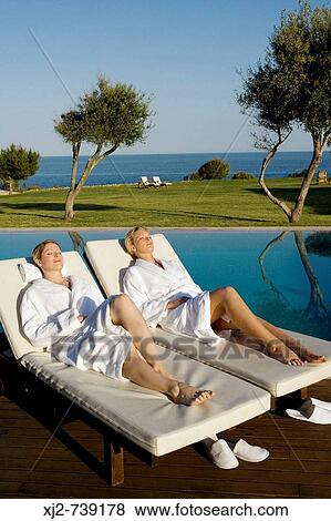Two women relaxing on a sun lounger in a Hotel by the sea View Large Photo Image Stock Photo - Two women relaxing on a sun lounger in a Hotel by the sea. Fotosearch