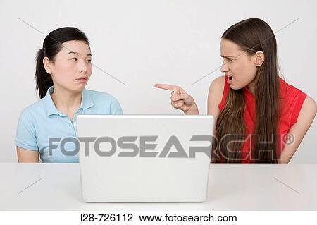 Stock Image - two women sitting at table. Fotosearch