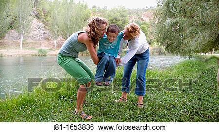Two women swinging a child View Large Photo Image Stock Photograph - Two women swinging a child. Fotosearch