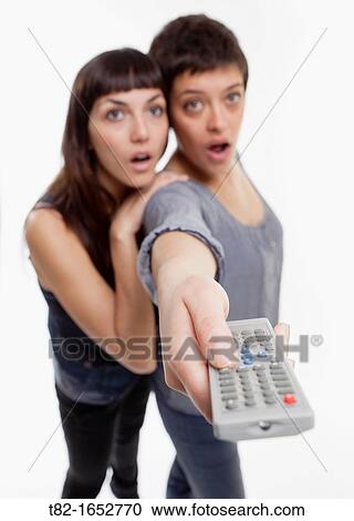 Two women using remote control View Large Photo Image Stock Image - Two women using remote control. Fotosearch