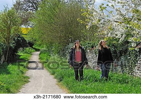 Stock Image - two women walking outside the village of Houdan, Yvelines department, Ile-de-France region, France, Europe.. Fotosearch