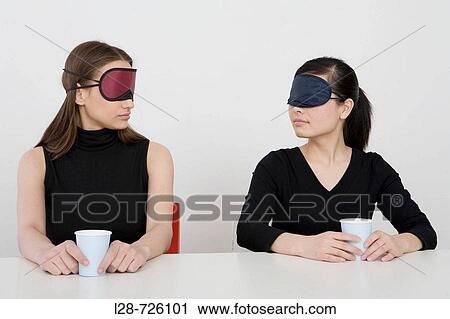 Two women wearing eye mask sitting at desk View Large Photo Image Stock Image - Two women wearing eye mask sitting at desk. Fotosearch