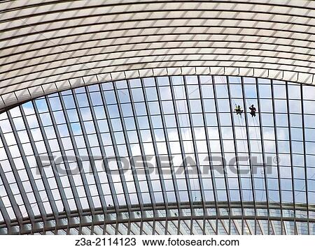 Stock Image - Two workers busy at the rooftop of the Liege railwaystation, Station Liege-Guillemins, Liege, Belgium, Europe.. Fotosearch