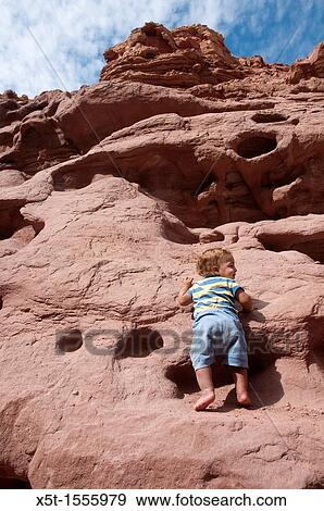 Stock Photo - Two year baby boy mountain climbing. Fotosearch