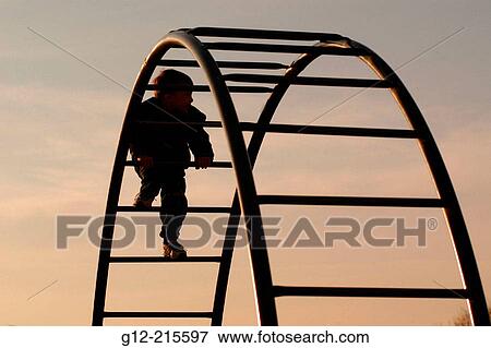 Two-year old boy climbing playground equipment View Large Photo Image Stock Photo - Two-year old boy climbing playground equipment. Fotosearch