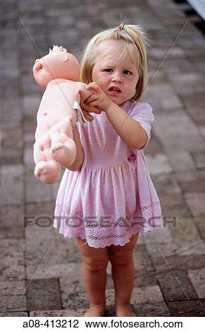 Stock Image - Two year old girl and her doll on brick patio. Pennsylvania. USA.. Fotosearch