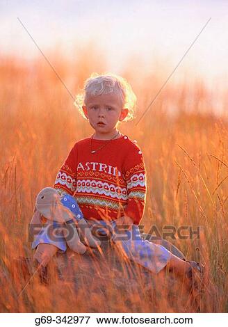 Two year old girl on a stone in evening light. V? sterbotten, Sweden View Large Photo Image Stock Photo - Two year old girl on a stone in evening light. V? sterbotten, Sweden. Fotosearch