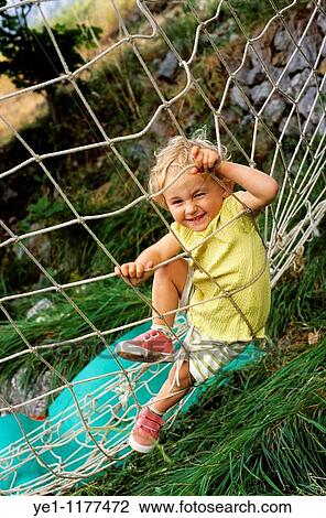 Two year old girl playing on a climbing net. View Large Photo Image Stock Image - Two year old girl playing on a climbing net.. Fotosearch