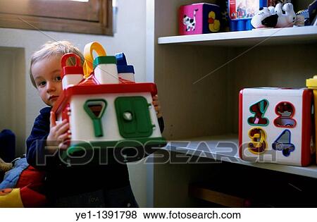 Two year old girl playing with toys in her bedroom View Large Photo Image Stock Photo - Two year old girl playing with toys in her bedroom. Fotosearch