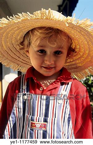 Two year old girl wearing dungarees and a large straw hat, France. View Large Photo Image Stock Photo - Two year old girl wearing dungarees and a large straw hat, France.. Fotosearch