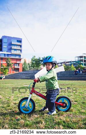 Picture - Two years old baby riding his bike in a park. Vilanova i la Geltru, Barcelona Spain. Fotosearch