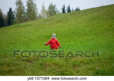 Picture - Two Years Old Girl Running in Hilly Green Meadow. Fotosearch