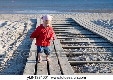 Stock Image - Two Years Old Kid Girl in Red Clothes on P? rnu Beach, Estonia, Europe. Fotosearch