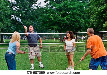 Stock Photo - Two young ( 20? s) couples playing badminton.. Fotosearch
