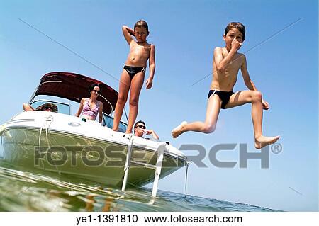 Two young boys jumping from a boat into the sea near Biscarrosse, Bordeaux, France View Large Photo Image Stock Image - Two young boys jumping from a boat into the sea near Biscarrosse, Bordeaux, France. Fotosearch