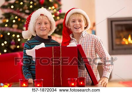 Two young boys opening a Christmas present on Christmas day View Large Photo Image Picture - Two young boys opening a Christmas present on Christmas day. Fotosearch