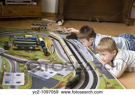 Two young boys playing with their electric trainset indoors View Large Photo Image Stock Photo - Two young boys playing with their electric trainset indoors. Fotosearch