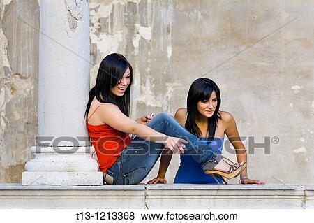 Two young female friends are looking at someone View Large Photo Image Stock Photo - Two young female friends are looking at someone. Fotosearch