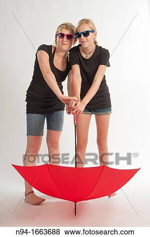 Stock Photo - Two young German girls playing with an umbrella.. Fotosearch