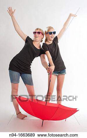 Stock Photo - Two young German girls playing with an umbrella.. Fotosearch