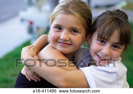 two young girls hugging and smiling View Large Photo Image Stock Photography - two young girls hugging and smiling. Fotosearch