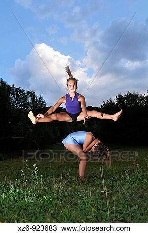 two young gymnasts jumping in a meadow at dusk View Large Photo Image Stock Image - two young gymnasts jumping in a meadow at dusk. Fotosearch