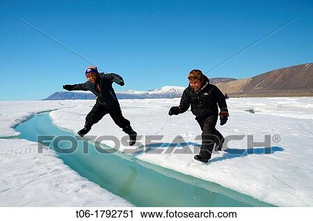Two young Inuit boys jumping over a crack on ice floe Ellesmere island, Nanavut, Canada View Large Photo Image Stock Image - Two young Inuit boys jumping over a crack on ice floe Ellesmere island, Nanavut, Canada. Fotosearch
