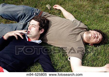 Two young men resting on grass View Large Photo Image Stock Photography - Two young men resting on grass. Fotosearch