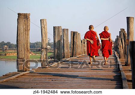 Picture - Two young monks crossing U Bein bridge. Myanmar, Mandalay, Amarapura, U Bein.. Fotosearch