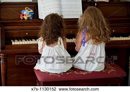 Two young sisters playing piano together View Large Photo Image Stock Image - Two young sisters playing piano together. Fotosearch