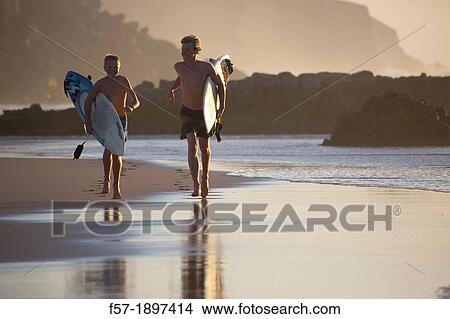 Picture - Two young surfers on Cotillo beach in Fuerteventura, Spain. Fotosearch