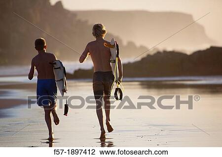 Two young surfers on Cotillo beach in Fuerteventura, Spain View Large Photo Image Stock Image - Two young surfers on Cotillo beach in Fuerteventura, Spain. Fotosearch