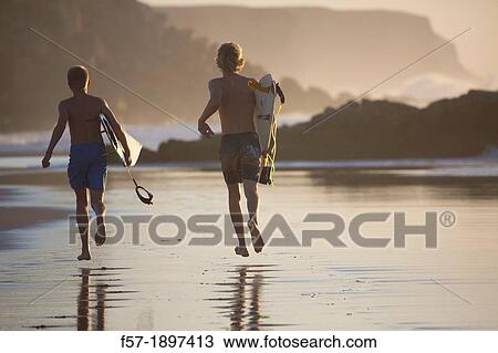 Two young surfers on Cotillo beach in Fuerteventura, Spain View Large Photo Image Stock Image - Two young surfers on Cotillo beach in Fuerteventura, Spain. Fotosearch