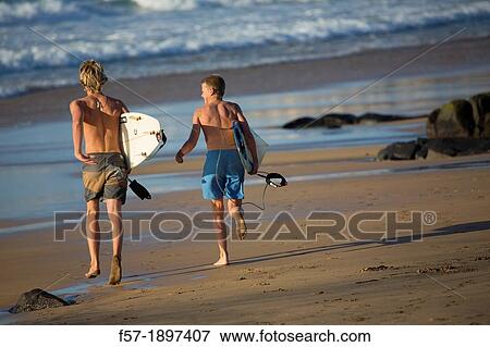 Two young surfers on El Cotillo beach in Fuerteventura, Spain View Large Photo Image Stock Photo - Two young surfers on El Cotillo beach in Fuerteventura, Spain. Fotosearch