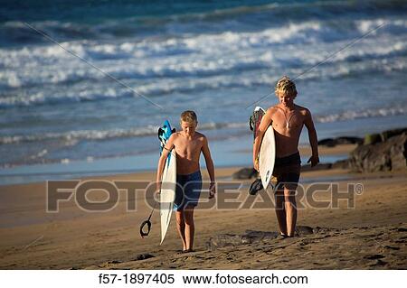 Two young surfers on El Cotillo beach in Fuerteventura, Spain View Large Photo Image Stock Photography - Two young surfers on El Cotillo beach in Fuerteventura, Spain. Fotosearch