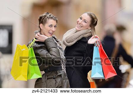 Two young woman with their bags from a shopping tour in a city in Germany. View Large Photo Image Stock Image - Two young woman with their bags from a shopping tour in a city in Germany.. Fotosearch