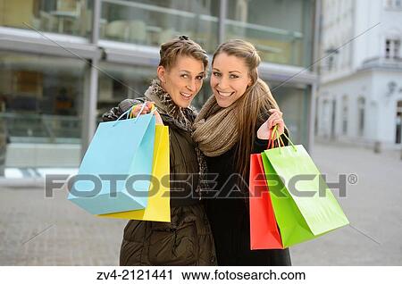 Two young woman with their bags from a shopping tour in a city in Germany. View Large Photo Image Stock Image - Two young woman with their bags from a shopping tour in a city in Germany.. Fotosearch