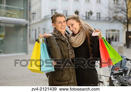 Two young woman with their bags from a shopping tour in a city in Germany. View Large Photo Image Stock Photo - Two young woman with their bags from a shopping tour in a city in Germany.. Fotosearch